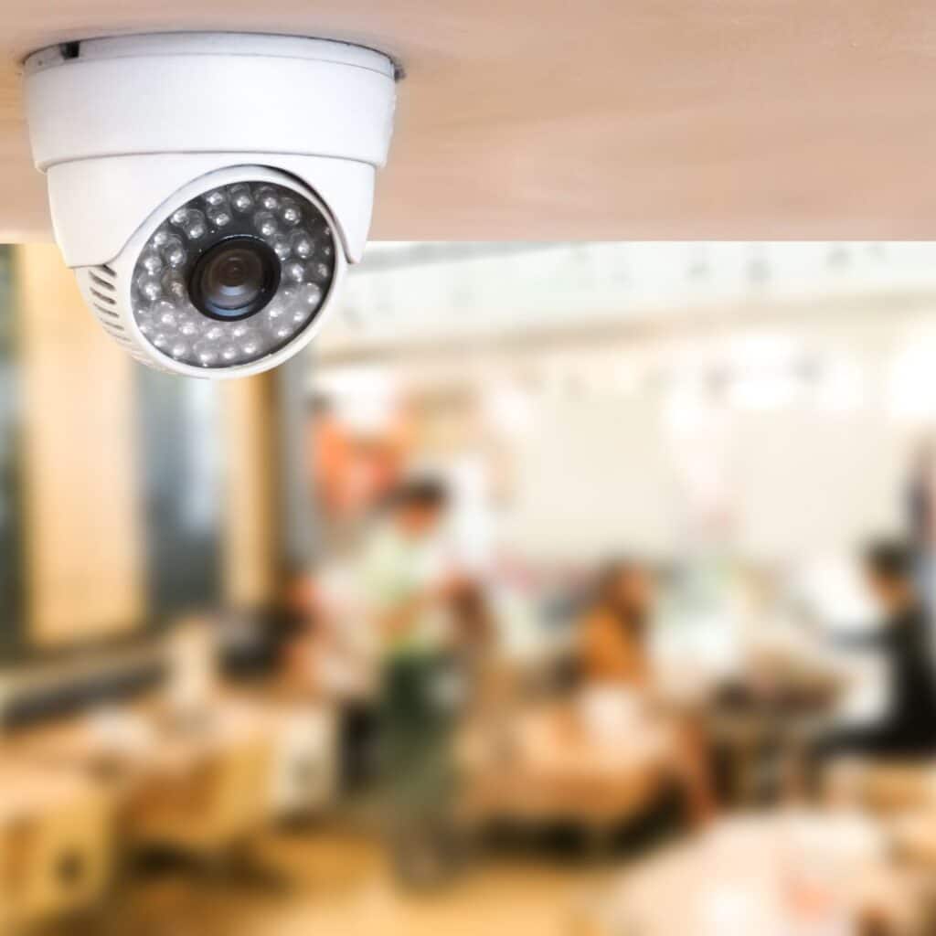 security camera on ceiling, blurry background — perhaps a restaurant